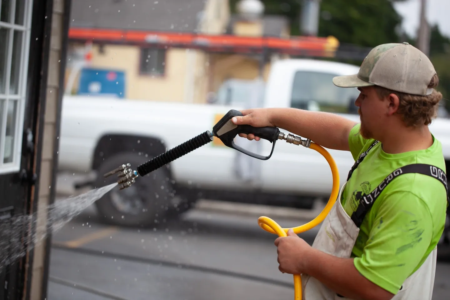 Person power washing a surface outdoors.